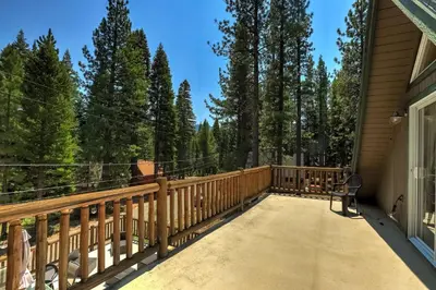 a wooden deck with a chair on it at Bear Pause 4BR - Large Deck & Balcony in South Lake Tahoe