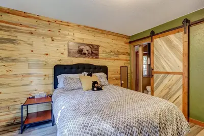 a bedroom with a bed and a wooden wall at The Blue Lake House - Family fun Abound in South Lake Tahoe