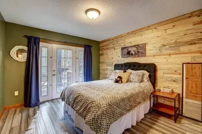 a bedroom with a bed and a wooden wall at The Blue Lake House - Family fun Abound in South Lake Tahoe