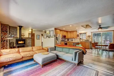 a living room with a couch and a kitchen at The Blue Lake House - Family fun Abound in South Lake Tahoe