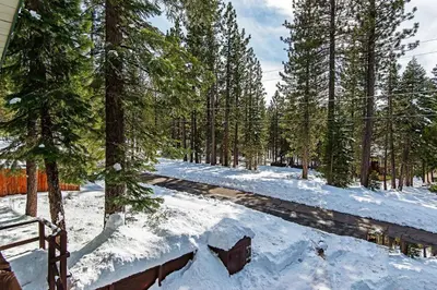 a road in the woods with snow on the ground at Cherry Hills Cabin - Sleeps 6 No Pets Family Fun in South Lake Tahoe