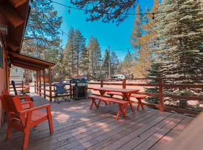 a wooden deck with a picnic table and chairs at Christmas Valley Chalet - Tahoe Adventure Awaits in South Lake Tahoe