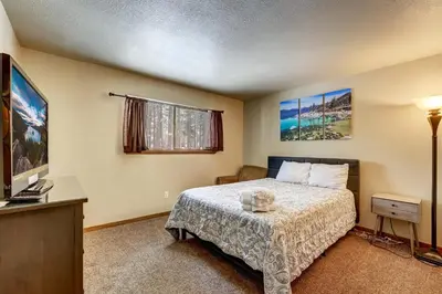 a small bedroom with a bed and a television at Cold Creek Chalet - Hot tub & Movie Room in South Lake Tahoe
