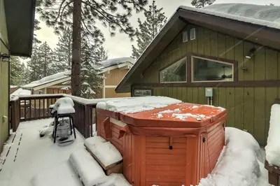 a snow covered hot tub on a deck in front of a house at Cold Creek Chalet - Hot tub & Movie Room in South Lake Tahoe