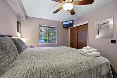 a bedroom with a bed with a ceiling fan and a window at Ski In Ski Out 3 BDR Steps from Stagecoach Lift in Stateline