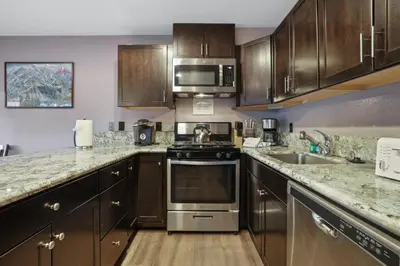 a kitchen with stainless steel appliances and wooden cabinets at Ski In Ski Out 3 BDR Steps from Stagecoach Lift in Stateline