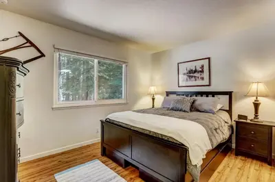 a bedroom with a large bed and a window at Coziness Cabin - Cute little cabin in the Tahoe woods in South Lake Tahoe