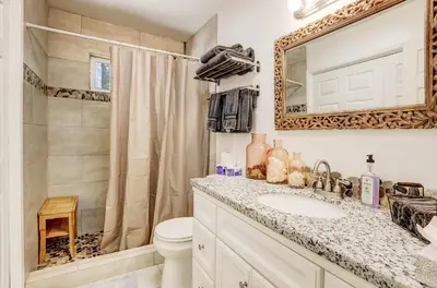 a bathroom with a sink and a toilet and a mirror at Coziness Cabin - Cute little cabin in the Tahoe woods in South Lake Tahoe