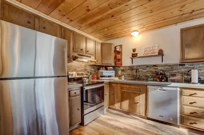 a kitchen with wooden cabinets and a refrigerator at Come Snuggle Up at Cozy Bear Cabin in South Lake Tahoe