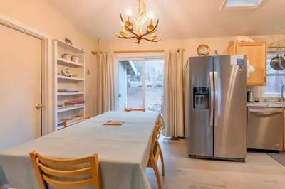 a kitchen with a long table and a refrigerator at Elk Forest Escape - Economy Family Abode in South Lake Tahoe