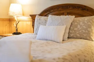 a bed with white pillows and a wooden headboard at Shady Pines Pets Hot tub in South Lake Tahoe
