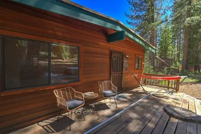 a deck of a cabin with chairs and a table at Shady Pines Pets Hot tub in South Lake Tahoe
