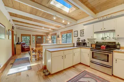 a kitchen with white cabinets and a wooden ceiling at Shady Pines Pets Hot tub in South Lake Tahoe