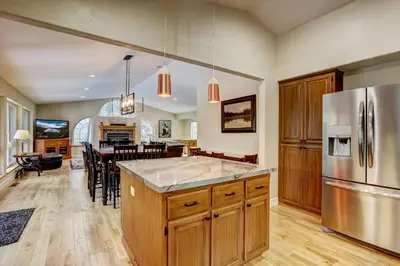 a kitchen and dining room with a stainless steel refrigerator at Nestled Pines Retreat Hot Tub Pool Tahoe Foosball More in South Lake Tahoe