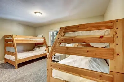 a bedroom with two bunk beds in a house at Nestled Pines Retreat Hot Tub Pool Tahoe Foosball More in South Lake Tahoe