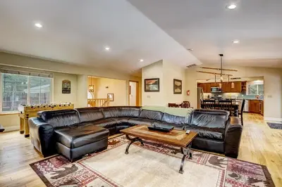 a living room with a leather couch and a table at Nestled Pines Retreat Hot Tub Pool Tahoe Foosball More in South Lake Tahoe