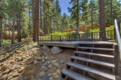 a wooden deck in the middle of a forest at Prima Del Norte - Hot tub Pool Table Arcade Game in South Lake Tahoe