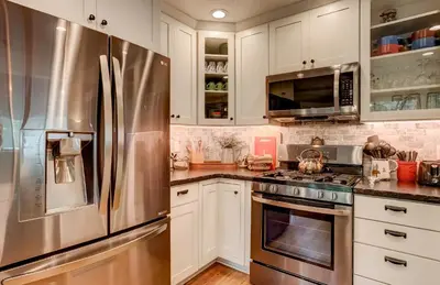 a kitchen with white cabinets and a stainless steel refrigerator at Serenity Woods - Game Room & More in South Lake Tahoe