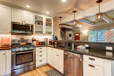 a kitchen with white cabinets and stainless steel appliances at Serenity Woods - Game Room & More in South Lake Tahoe