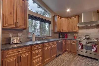 a kitchen with wooden cabinets and a sink and a stove at Silver Pines - Ski or Summer 30 plus day home in South Lake Tahoe