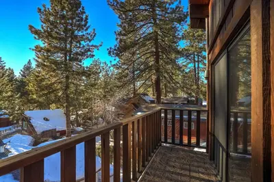 a deck with a view of the snow covered trees at Singing Pines in Marla Bay - Walk to Lake in Glenbrook