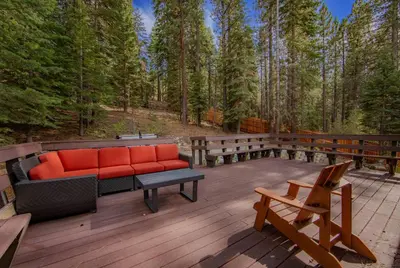 a patio with a couch on a deck in the woods at Southern Pines Arcade Games & Foosball for Kids in South Lake Tahoe