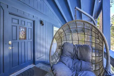 a wicker chair in a blue room with a door at Southern Pines Arcade Games & Foosball for Kids in South Lake Tahoe
