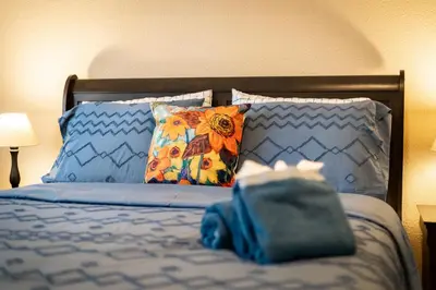 a bed with pillows and a blue bag on it at Sutter Trail Sparkles - Air conditioned large family home in South Lake Tahoe