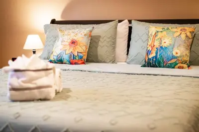 a bed with pillows and a table with a lamp at Sutter Trail Sparkles - Air conditioned large family home in South Lake Tahoe