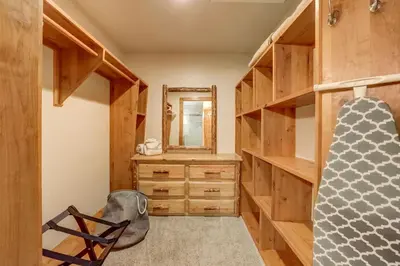 a walk in closet with wooden cabinets and a mirror at Sutter Trail Sparkles - Air conditioned large family home in South Lake Tahoe