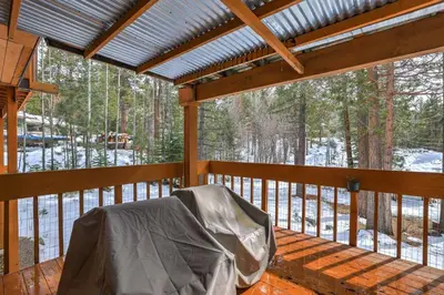 a screened in porch with a view of the woods at Tahoe Forest Chalet 3BR House with AC in Stateline