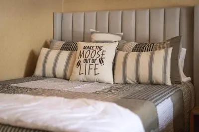 a bed with several pillows on top of it at Tahoe Forest Chalet 3BR House with AC in Stateline