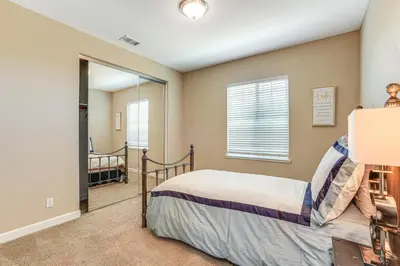 a bedroom with a bed and a mirror at 4 Mi to The Streets of Brentwood Home with Fire Pit in Brentwood