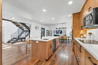a kitchen with wooden cabinets and a staircase at Family Retreat Mountain View with Hot Tub and Mini Golf in Steamboat