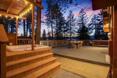 a porch with a tub and a table on a deck at Mountainside Overlook Lake Views & Hot Tub in Kings Beach