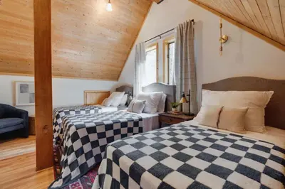 two beds in a room with wooden ceilings at North Lake Hideaway Prime Locale for Outdoor Fun in Alpine Meadows