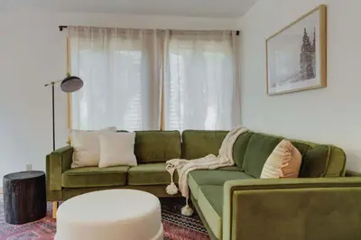 a living room with a green couch and a table at North Lake Hideaway Prime Locale for Outdoor Fun in Alpine Meadows