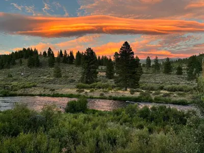 a sunset over a river in a field with trees at Luxury Northstar Palace with Hot Tub & Games in Truckee
