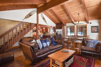 a living room with leather furniture and a staircase at Northstar Treehouse Chic 4BR House Forest view in Truckee