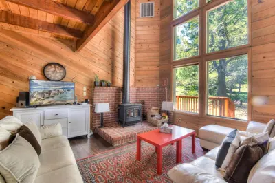 a living room with a fireplace in a log cabin at Northwoods Hangout Near Tahoe Donner in Truckee