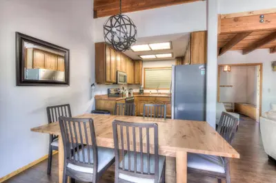 a kitchen with a wooden table and chairs and a refrigerator at Northwoods Hangout Near Tahoe Donner in Truckee