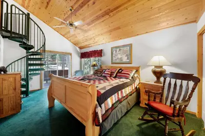 a bedroom with a bed and a chair and a staircase at Paradise Pines 3BR Secluded Cabin Minutes in Tahoe Donner in Truckee