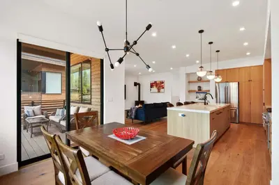 a kitchen and living room with a wooden table and chairs at Enjoy Paradise Hot Tub Bike & Beach Equipment in Olympic Valley