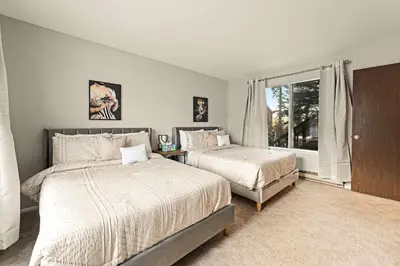 a bedroom with two beds and a window at Powder Run Retreat Modern Stay for 6 With On-site Ski Access & Mountain Views in Truckee