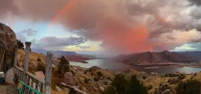a rainbow in the sky over a body of water at Lord of the rings palice in Wofford Heights