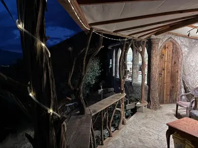 an outdoor patio with a wooden bench and lights at Lord of the rings palice in Wofford Heights