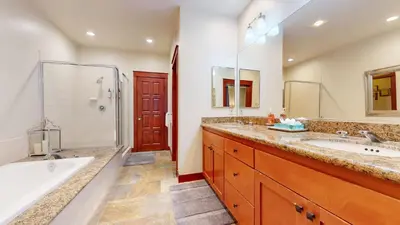 a bathroom with two sinks and a tub and a shower at Timbers #2 townhouse in Mammoth Lakes