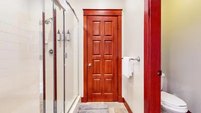 a bathroom with a shower and a wooden door at Timbers #2 townhouse in Mammoth Lakes