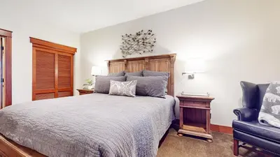 a bedroom with a bed and a blue chair at Timbers #2 townhouse in Mammoth Lakes
