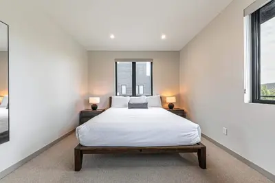 a bedroom with a large bed and two windows at Village Walk 7470 by East West Hospitality in Truckee